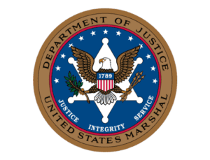 The official seal of the united states department of justice featuring an eagle holding an olive branch and arrows, surrounded by a blue circle with the words "department of justice," "united states marshal," along with the year "1789.