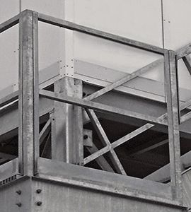 Close-up of a galvanized steel framework with multiple beams and riveted connections, showcasing an industrial construction detail for guard rails.