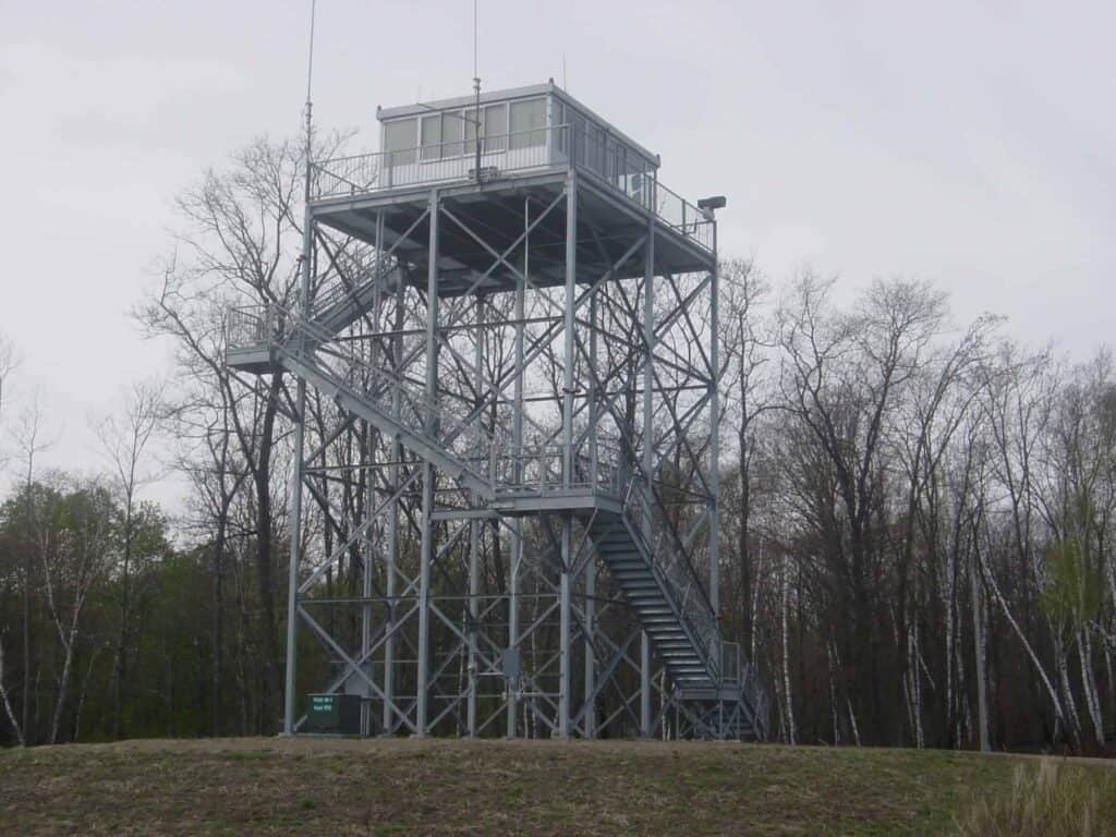 large grey guard tower with trees in the background