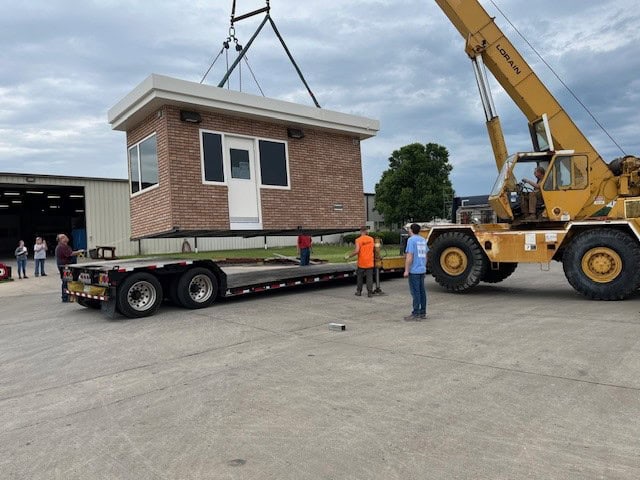 Guard booth with brick exterior being delivered